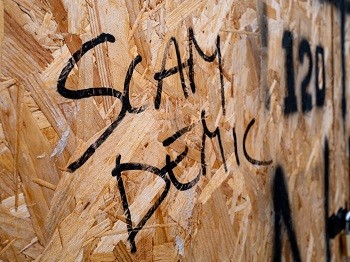 Una pared de tablero de partículas expuesta con "SAMDEMIC" pintado con spray sobre él.