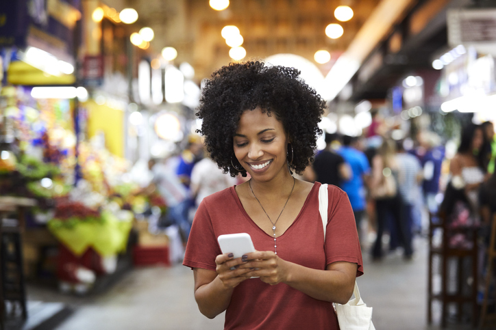 Mujer sonriente con teléfonos inteligentes en el supermercado