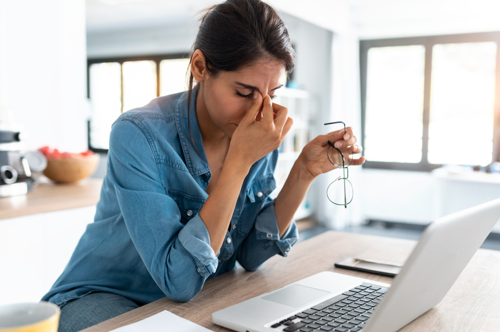 Mujer que trabaja en su computadora portátil experimentando pensamientos intrusivos